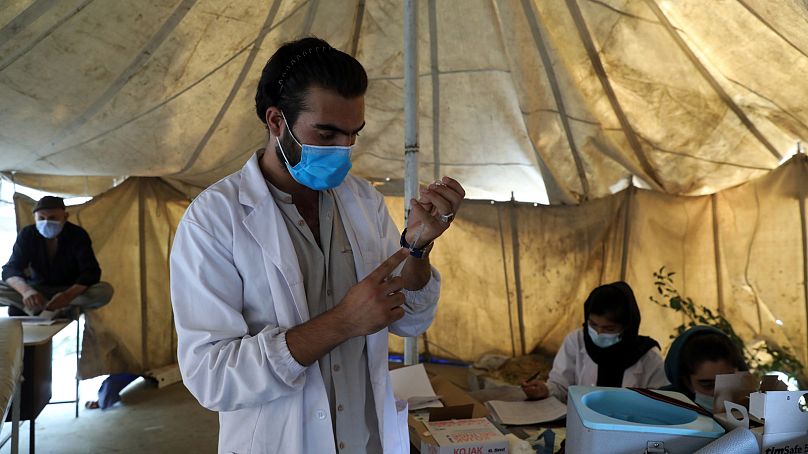 A doctor fills a syringe with the Johnson & Johnson COVID-19 vaccine donated through the UN-backed COVAX program at a vaccination center in Kabul, Afghanistan, 2021.